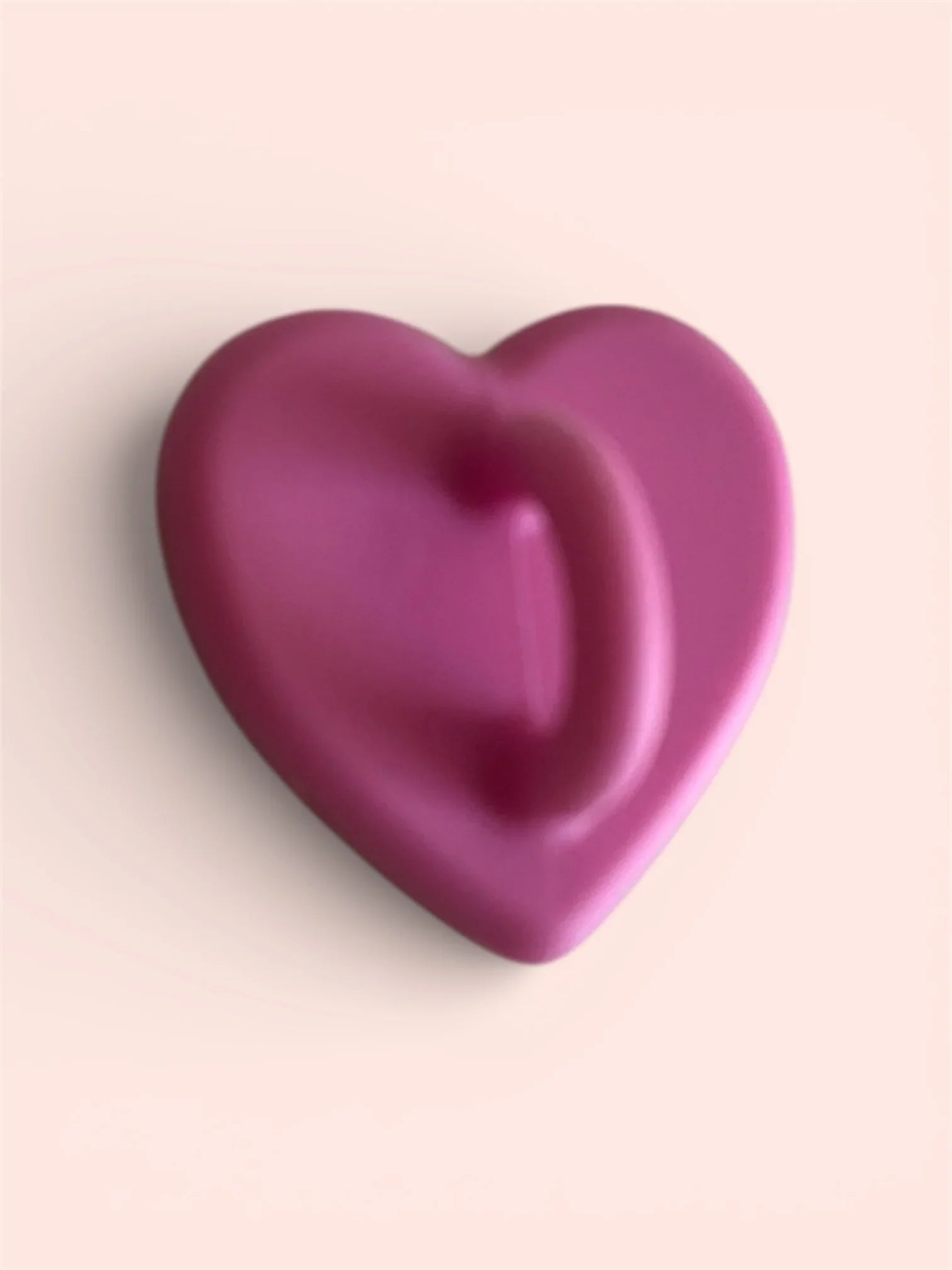 Smooth pink heart-shaped object on soft background
