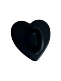 Black heart-shaped object with smooth matte finish on light background