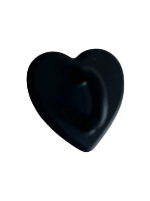 Black heart-shaped object with smooth matte finish on light background