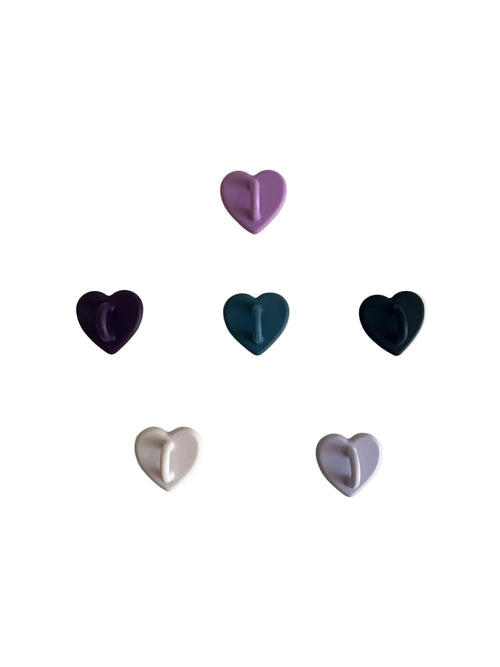 Heart-shaped wall hooks in purple, blue, black, and beige for home organization