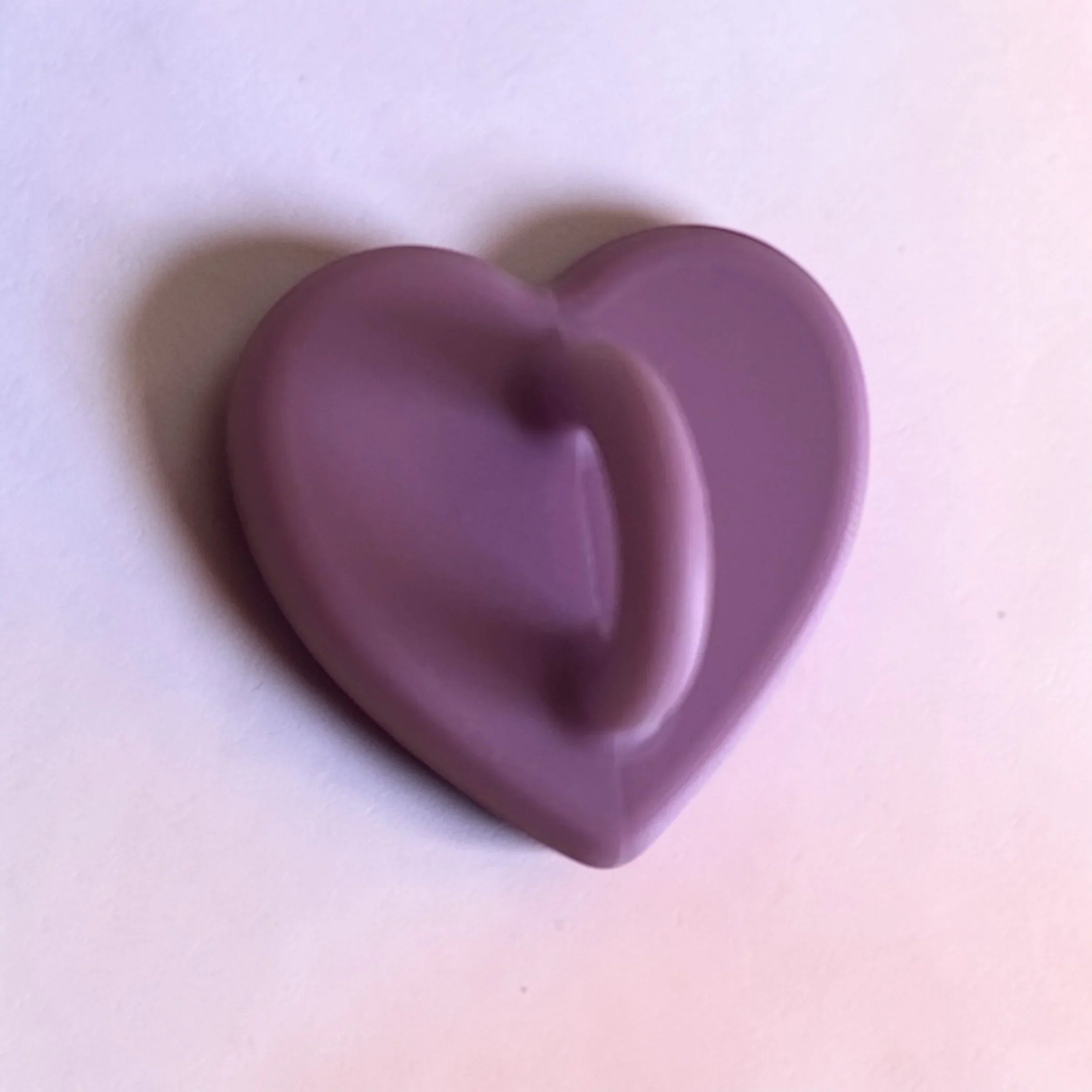 Purple heart-shaped soap bar on white background, gentle skincare for daily use