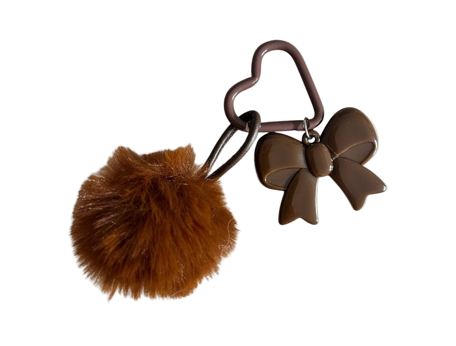 Brown keychain with a fluffy ball and bow design on a beige background