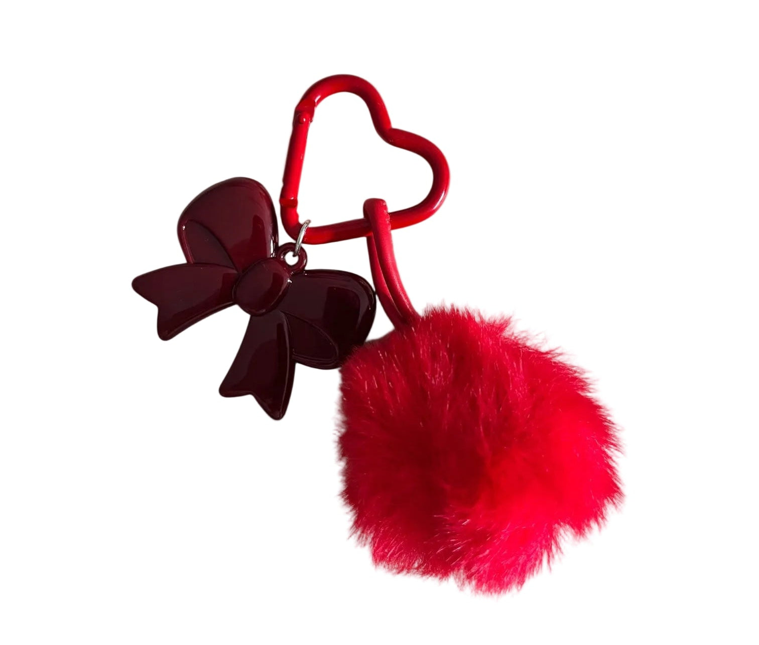 Red heart-shaped keychain with a bow and red pom-pom on a light gray background