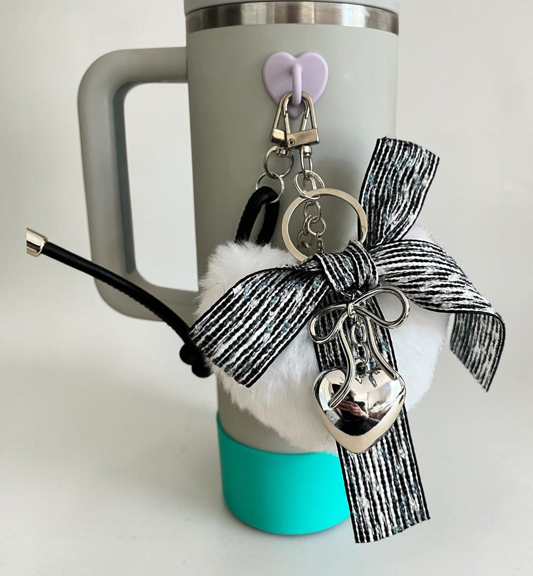 Gray mug with turquoise base, decorative bow, and keychain on a light gray background