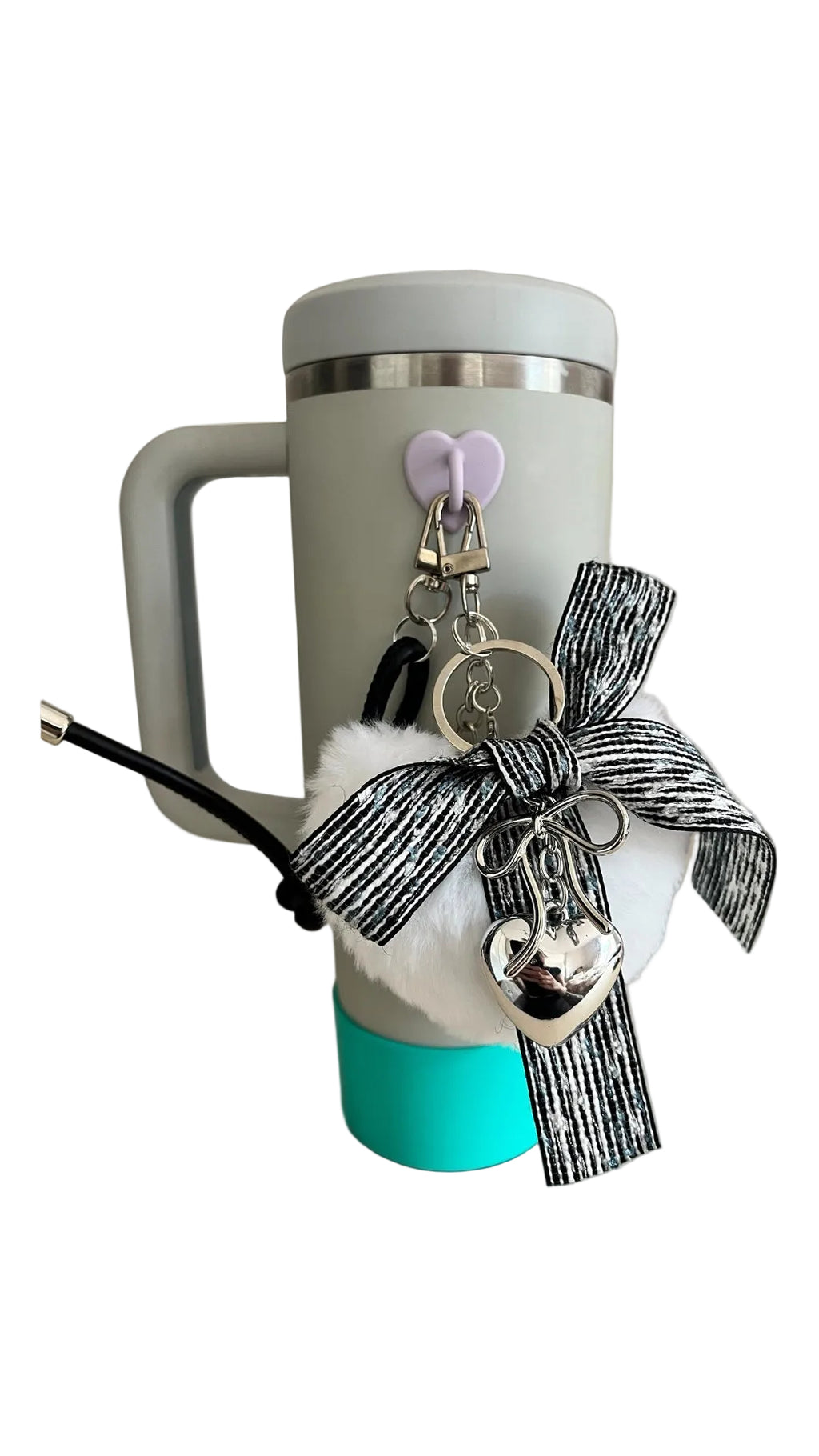 White mug with turquoise base, decorative bow, and keychain on a light background