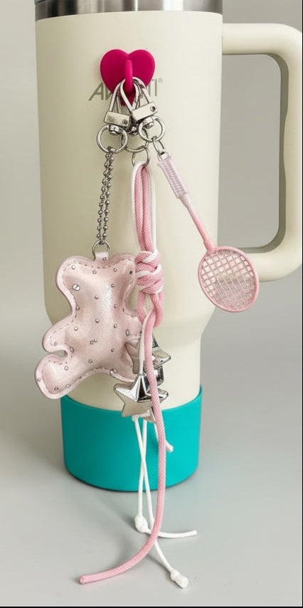White tumbler with teal base and pink accessories on a neutral background