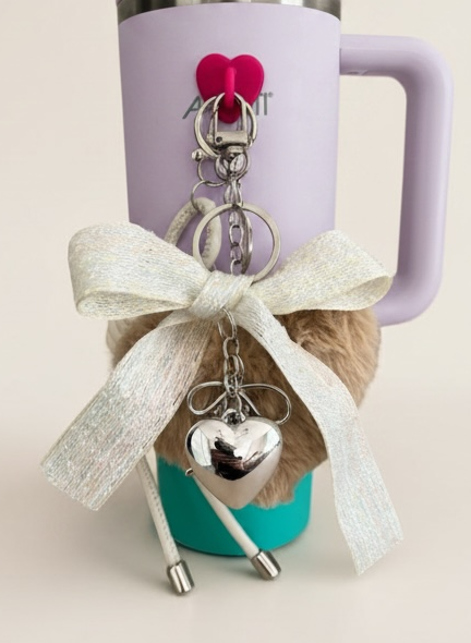 Purple mug with a keychain featuring heart charms on a beige background
